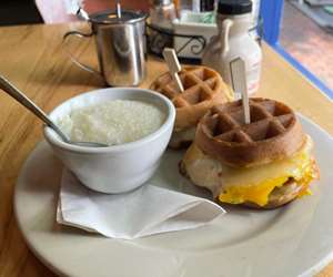Egg sandwiches made on mini waffles with a side of grits