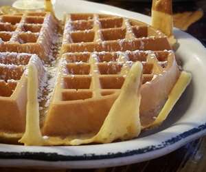 A piping-hot waffle with a sprinkle of powdered sugar